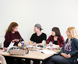 A group of 4 students having a discussion at a table